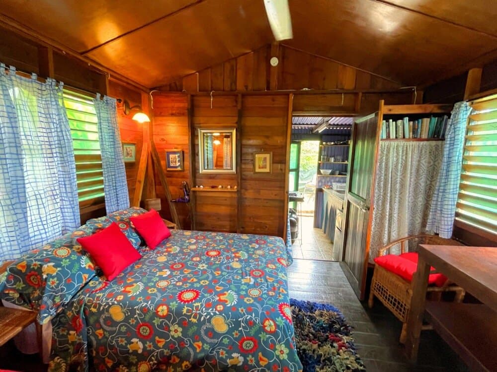 Judy House Cottage bedroom sleeps 1, 2 or 3 persons; double and twin bed; with new fan and AC (2025); fully equipped kitchen and Air Fryer; hot water bathroom with shower; safe box and storage; verandah with table, chairs and hammock; patio with table, chairs and sun loungers; in beautiful tropical gardens; recycling area; fenced and gated with 24 Hours security.